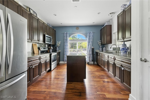 4440 40th St NE, Naples, FL 34120 - kitchen with stainless steel appliances, a center island, dark brown cabinetry, dark wood finished floors, and recessed lighting