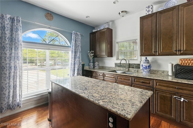 4440 40th St NE, Naples, FL 34120 - kitchen with light stone countertops, plenty of natural light, dark wood-style flooring, and a center island