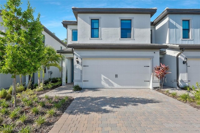 4184 Sonoma Oaks Cir, Naples, FL 34119 - view of front of property featuring an attached garage, stucco siding, and decorative driveway