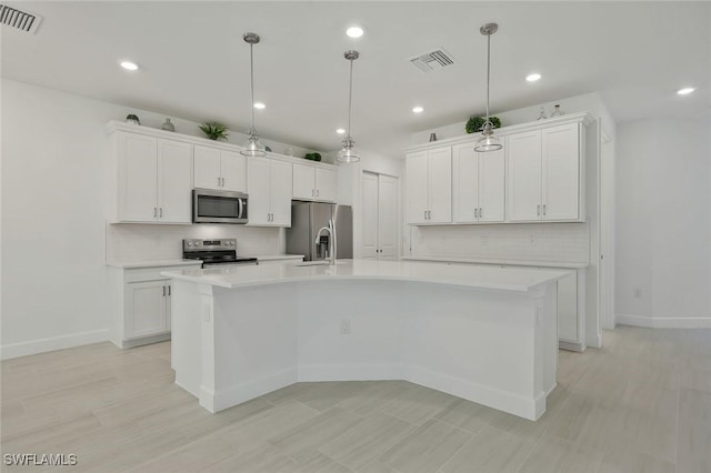 4184 Sonoma Oaks Cir, Naples, FL 34119 - kitchen with appliances with stainless steel finishes, light countertops, a large island with sink, white cabinets, and recessed lighting