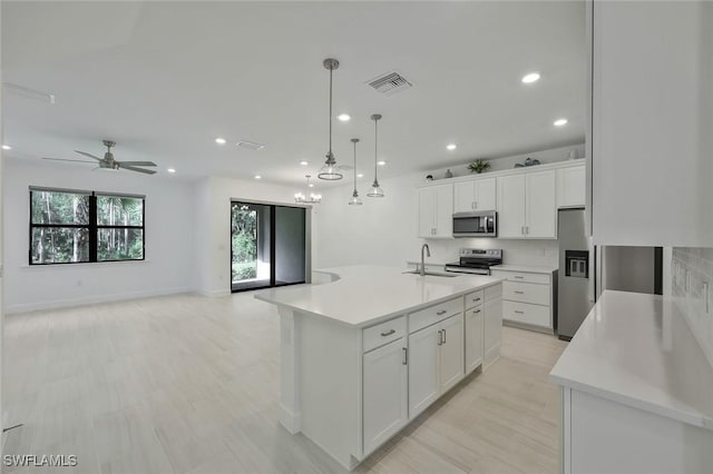 4184 Sonoma Oaks Cir, Naples, FL 34119 - kitchen featuring stainless steel appliances, white cabinetry, light countertops, recessed lighting, and decorative light fixtures