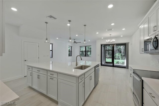 4184 Sonoma Oaks Cir, Naples, FL 34119 - kitchen with appliances with stainless steel finishes, light countertops, recessed lighting, white cabinetry, and decorative light fixtures