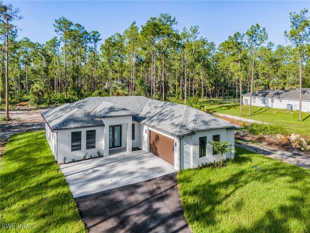 2717 10th Ave SE, Naples, FL 34117 - view of front facade with driveway, a shingled roof, a garage, and a front lawn