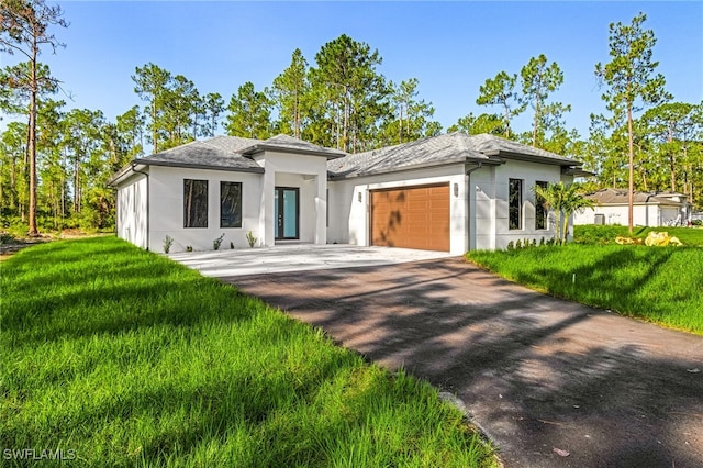 2717 10th Ave SE, Naples, FL 34117 - prairie-style house with a garage, stucco siding, driveway, and a front lawn