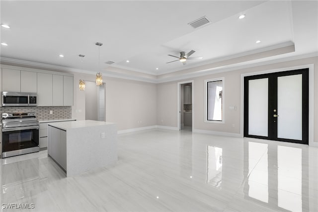 2717 10th Ave SE, Naples, FL 34117 - kitchen featuring appliances with stainless steel finishes, gray cabinets, crown molding, a tray ceiling, and light countertops