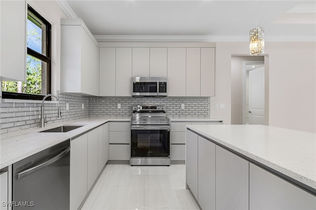 2717 10th Ave SE, Naples, FL 34117 - kitchen with stainless steel appliances, modern cabinets, backsplash, light stone counters, and crown molding