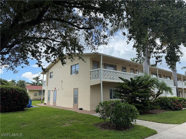 13150 Kings Point Dr Unit 11C, Fort Myers, FL 33919 - view of side of home featuring stucco siding, a yard, and a balcony