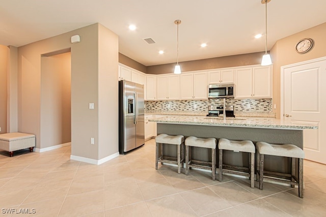 3943 E Hampton Cir, Alva, FL 33920 - kitchen with appliances with stainless steel finishes, decorative backsplash, white cabinets, a breakfast bar area, and light tile patterned floors