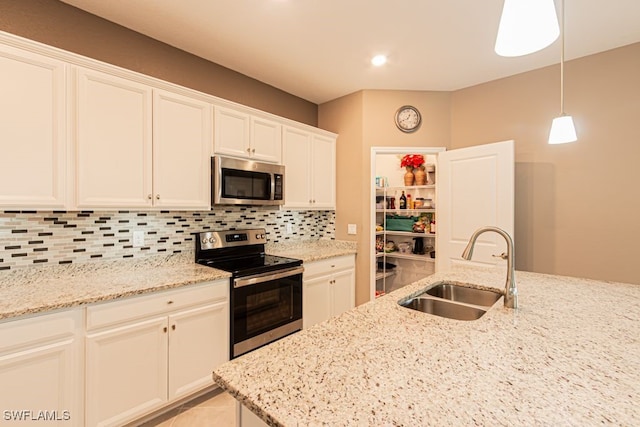 3943 E Hampton Cir, Alva, FL 33920 - kitchen with appliances with stainless steel finishes, tasteful backsplash, light stone counters, white cabinets, and pendant lighting