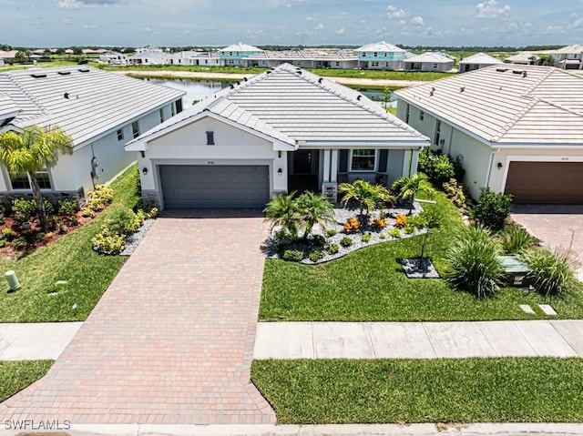 3943 E Hampton Cir, Alva, FL 33920 - view of front of property with a garage, decorative driveway, stucco siding, a front lawn, and a tile roof