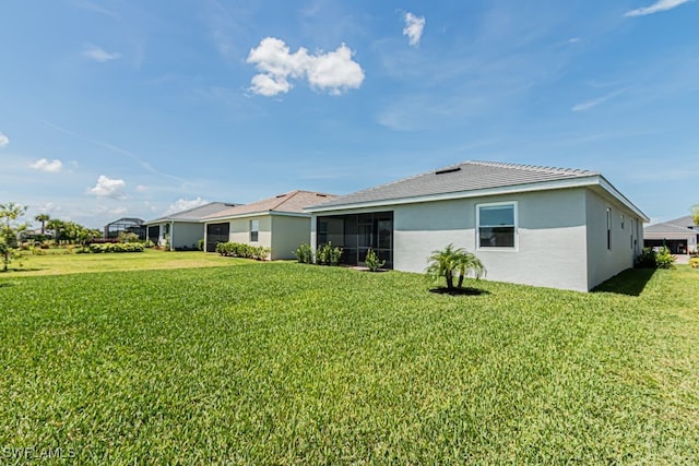 3943 E Hampton Cir, Alva, FL 33920 - rear view of house with a lawn, stucco siding, and a sunroom