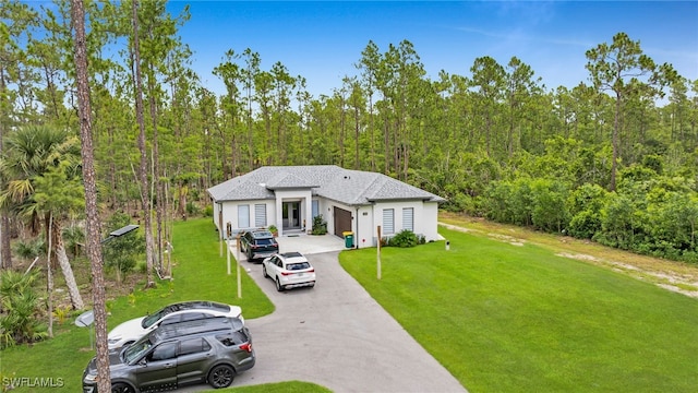 4267 4th Ave SE, Naples, FL 34117 - view of front facade with a front yard, a wooded view, driveway, and stucco siding