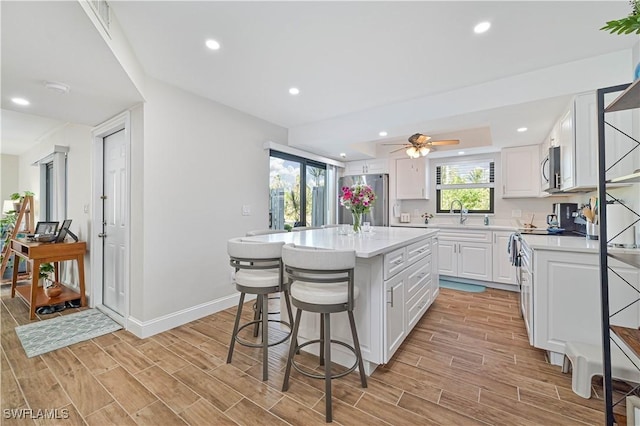 6296 Sugar Bush Ln Unit A, Fort Myers, FL 33908 - kitchen with appliances with stainless steel finishes, light countertops, a kitchen island, a kitchen breakfast bar, and recessed lighting