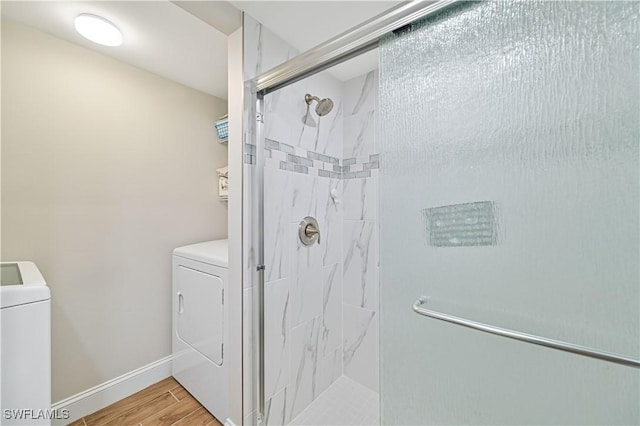 6296 Sugar Bush Ln Unit A, Fort Myers, FL 33908 - bathroom with washing machine and clothes dryer, a stall shower, and wood finished floors