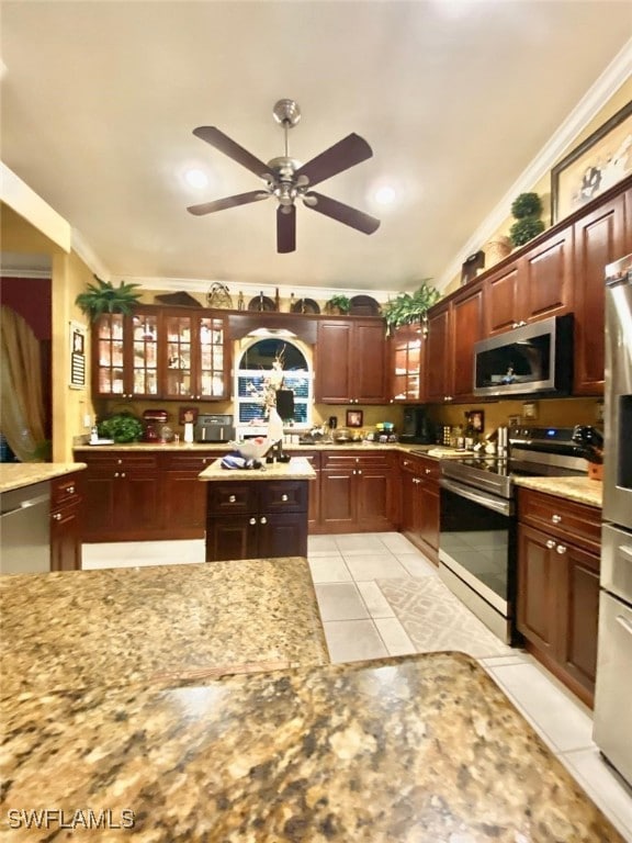 291 Everglades Blvd N, Naples, FL 34120 - kitchen with stainless steel appliances, a ceiling fan, ornamental molding, light tile patterned flooring, and glass insert cabinets