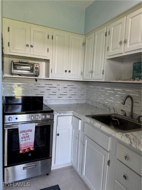 190 N Collier Blvd Unit O4, Marco Island, FL 34145 - kitchen with electric range, open shelves, backsplash, light tile patterned floors, and light stone counters