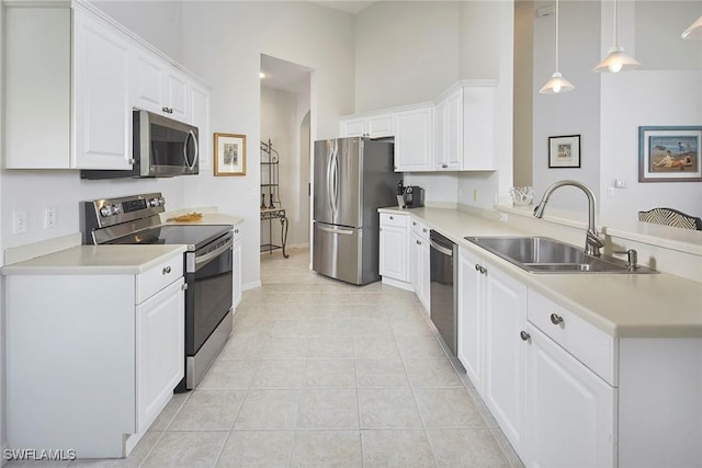 6275 Wilshire Pines Cir Unit 1008, Naples, FL 34109 - kitchen with stainless steel appliances, a peninsula, light countertops, white cabinetry, and a high ceiling
