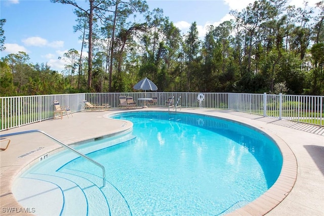 6275 Wilshire Pines Cir Unit 1008, Naples, FL 34109 - community pool with a patio and view of wooded area