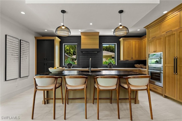 1261 13th Ave N, Naples, FL 34102 - kitchen featuring recessed lighting, double oven, dark countertops, a kitchen breakfast bar, and an island with sink