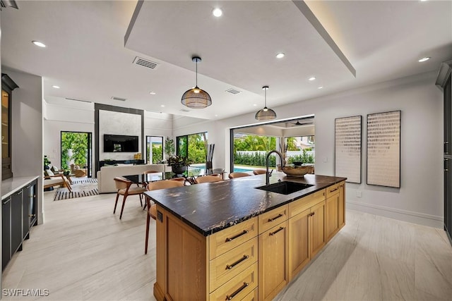 1261 13th Ave N, Naples, FL 34102 - kitchen featuring a center island with sink, recessed lighting, pendant lighting, open floor plan, and glass insert cabinets