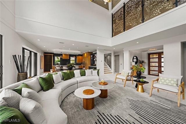 1261 13th Ave N, Naples, FL 34102 - living room featuring plenty of natural light, a towering ceiling, stairs, french doors, and recessed lighting