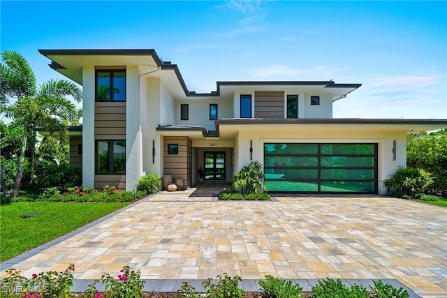 1261 13th Ave N, Naples, FL 34102 - view of front of house featuring stucco siding, decorative driveway, a garage, and french doors