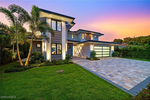 1261 13th Ave N, Naples, FL 34102 - modern home featuring decorative driveway, stucco siding, a front lawn, and an attached garage
