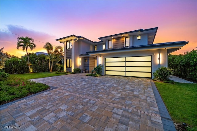 1261 13th Ave N, Naples, FL 34102 - view of front of house with decorative driveway, a lawn, stucco siding, and an attached garage