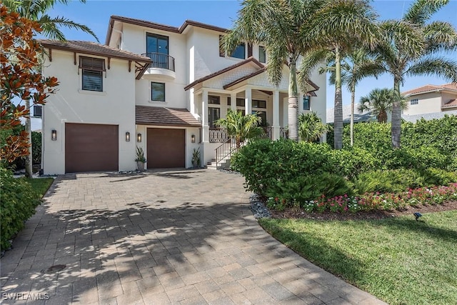 434 Trade Winds Ave, Naples, FL 34108 - mediterranean / spanish house with a garage, decorative driveway, stucco siding, and a balcony