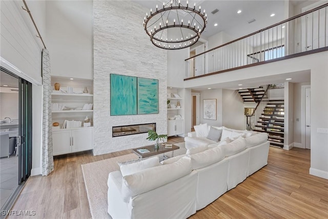 434 Trade Winds Ave, Naples, FL 34108 - living room with a high ceiling, stairway, a large fireplace, wood finished floors, and built in features