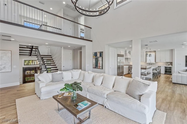 434 Trade Winds Ave, Naples, FL 34108 - living area featuring stairs, light wood-type flooring, a chandelier, recessed lighting, and wine cooler