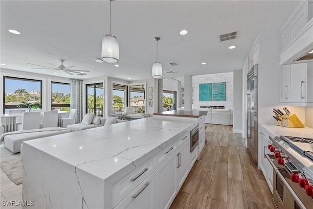 434 Trade Winds Ave, Naples, FL 34108 - kitchen with open floor plan, recessed lighting, premium appliances, a center island, and white cabinets