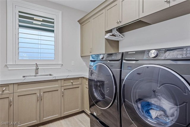 434 Trade Winds Ave, Naples, FL 34108 - washroom featuring washer and dryer, cabinet space, and light wood-type flooring