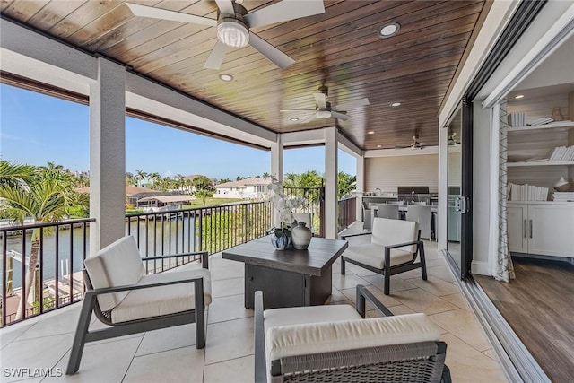 434 Trade Winds Ave, Naples, FL 34108 - view of patio featuring an outdoor kitchen, a ceiling fan, outdoor lounge area, and a water view
