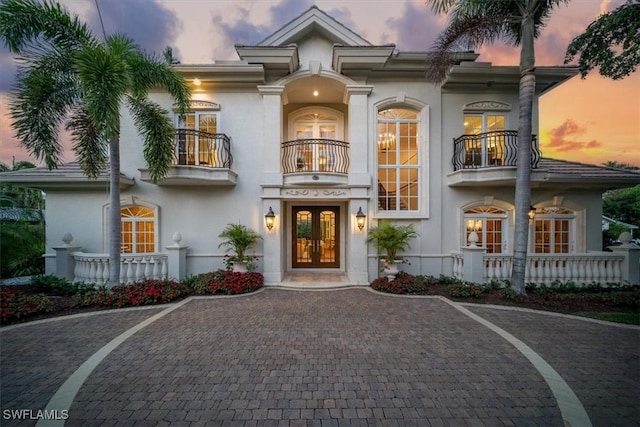 33 3rd St S, Naples, FL 34102 - view of front of house featuring a balcony, french doors, and stucco siding