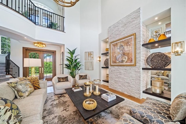 33 3rd St S, Naples, FL 34102 - living area featuring stairs, plenty of natural light, wood finished floors, a chandelier, and a high ceiling