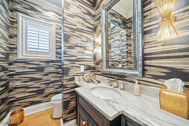 33 3rd St S, Naples, FL 34102 - half bath featuring wallpapered walls, vanity, and wood finished floors