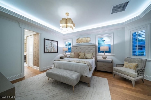 33 3rd St S, Naples, FL 34102 - bedroom with a chandelier, crown molding, wood finished floors, multiple windows, and a tray ceiling