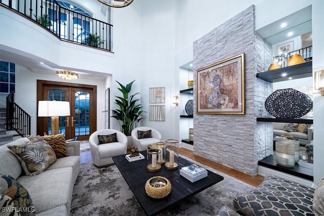 33 3rd St S, Naples, FL 34102 - living area with wood finished floors, stairway, a chandelier, a high ceiling, and french doors