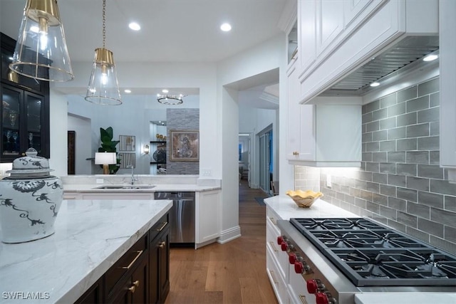 33 3rd St S, Naples, FL 34102 - kitchen featuring stainless steel appliances, wood finished floors, glass insert cabinets, premium range hood, and tasteful backsplash
