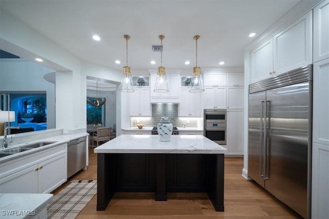 33 3rd St S, Naples, FL 34102 - kitchen featuring stainless steel appliances, decorative backsplash, white cabinets, and recessed lighting