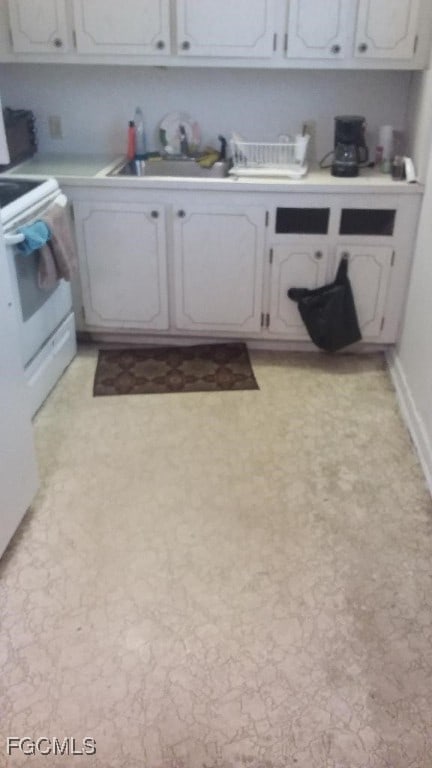 56 Brighton Unit B, Boca Raton, FL 33434 - kitchen with electric range, light countertops, and white cabinetry