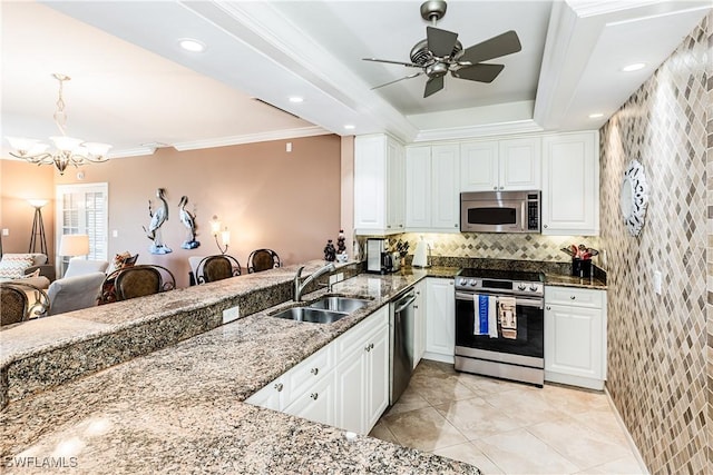 816 E Elkcam Cir Unit 305, Marco Island, FL 34145 - kitchen with appliances with stainless steel finishes, dark stone countertops, white cabinetry, a chandelier, and crown molding