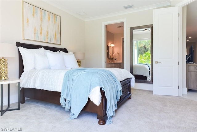 carpeted bedroom featuring ornamental molding and ensuite bathroom