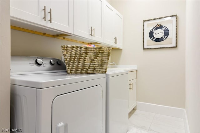 laundry room featuring light tile floors, cabinets, sink, and washing machine and dryer