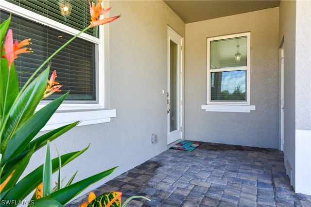 view of exterior entry featuring a patio area