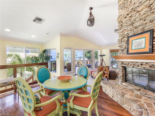 dining space with lofted ceiling, a fireplace, crown molding, and dark hardwood / wood-style flooring