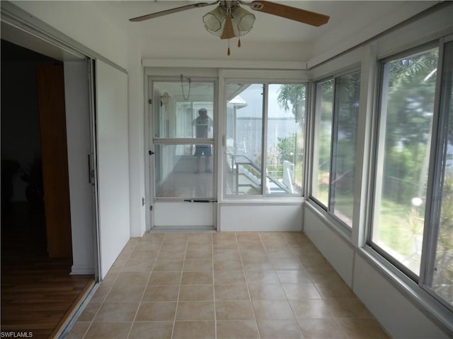 unfurnished sunroom featuring ceiling fan