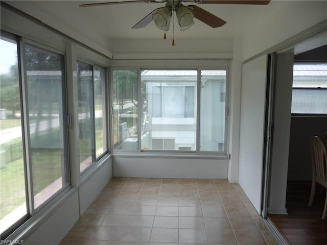 unfurnished sunroom with ceiling fan