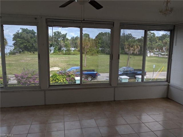 unfurnished sunroom with ceiling fan and a wealth of natural light